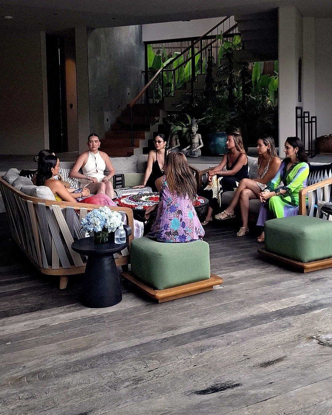 Group seated in a lounge around a flower arrangement