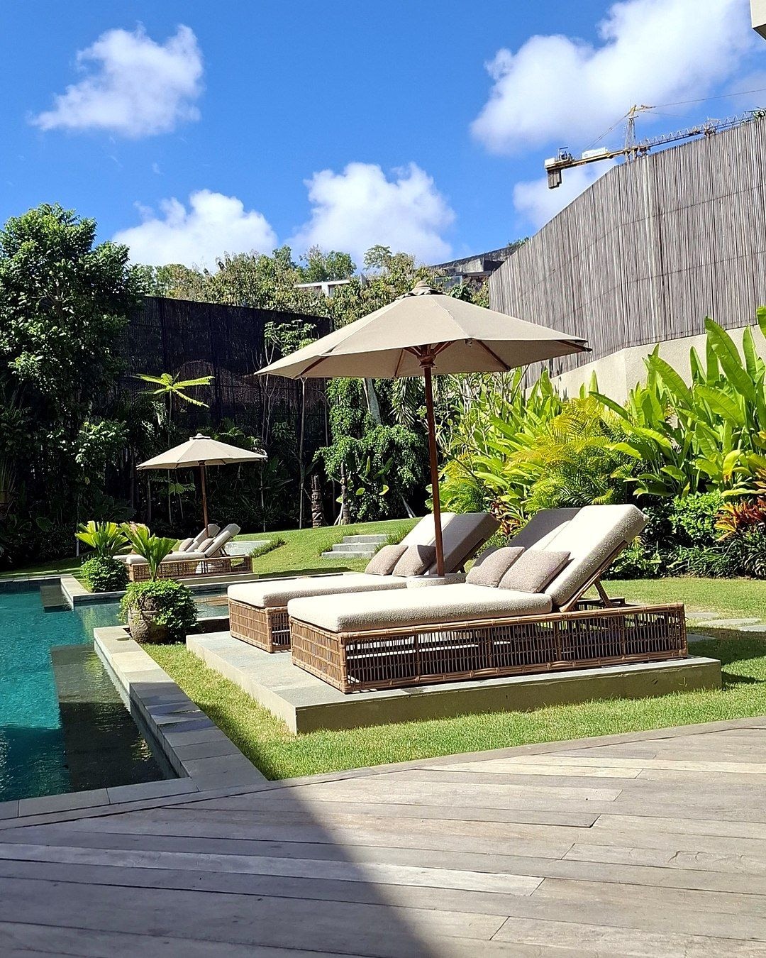 Poolside loungers and umbrellas in a tropical garden