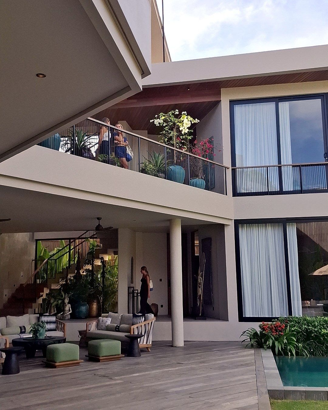 Villa courtyard with a wooden deck, lounge seating and swimming pool